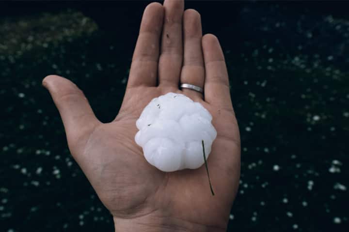 Hand holding very large piece of hail