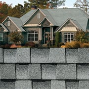 Swatch of gray Timberline HDZ shingles by GAF with beauty image on house.