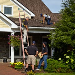 roofers installing shingles on a residential home
