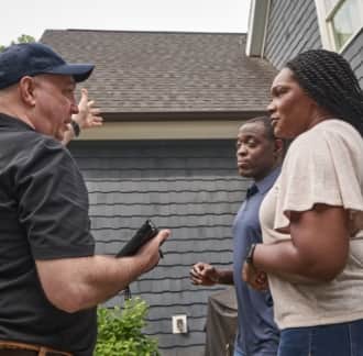 Man explaining to homeowners outside their home whether a policy covers the storm damage to their roof.