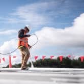 image of roofer spraying coatings materials on roof