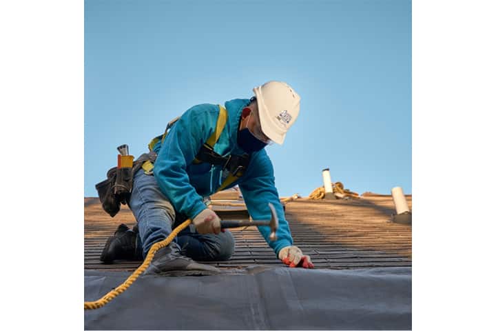 factory-certified roofer on top of a roof