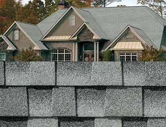 Swatch of Timberline HDZ Pewter Gray shingles with an image of the roof shingles on a display home.